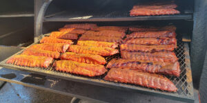 A smoker with ribs on the racks.