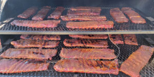 Ribs being smoked. A thermometer probe is being used to monitor temperature.